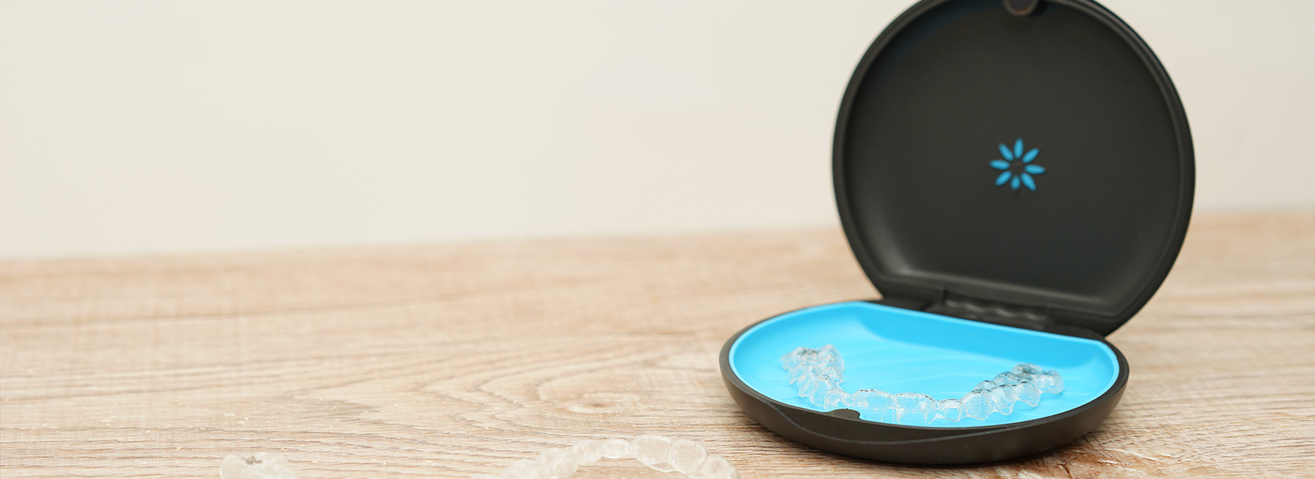 A blue smart home device with a black base, placed on a wooden surface.