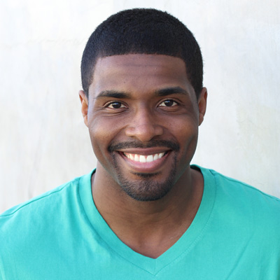 An elderly couple posing for a photo with smiles, the man is bald and the woman has gray hair.