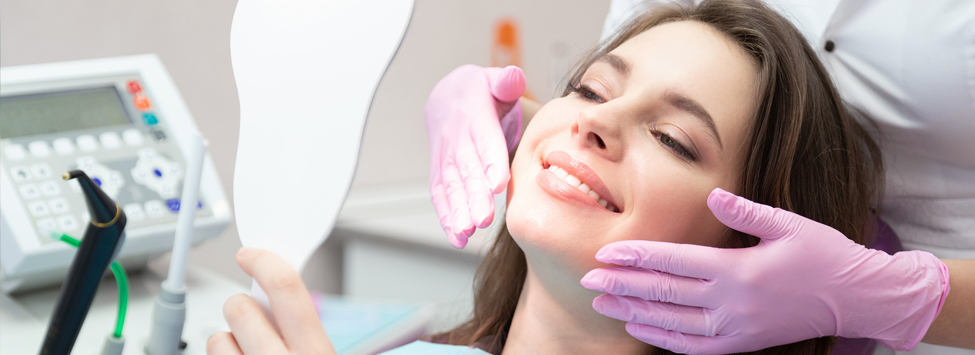 A woman receiving dental care, with a dentist s hand visible holding a dental instrument.