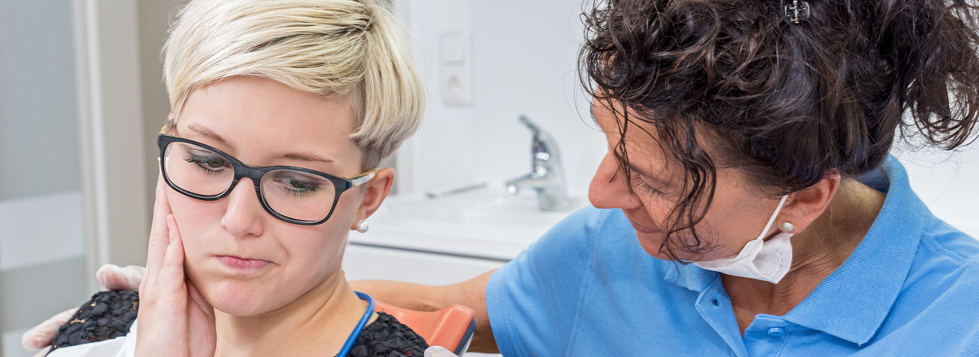 The image shows a professional hairdressing setting where a woman is performing a hair treatment on another person, with the focus on the person receiving the service.