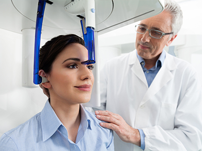 A medical professional assisting a patient with a dental device, likely in an office setting.